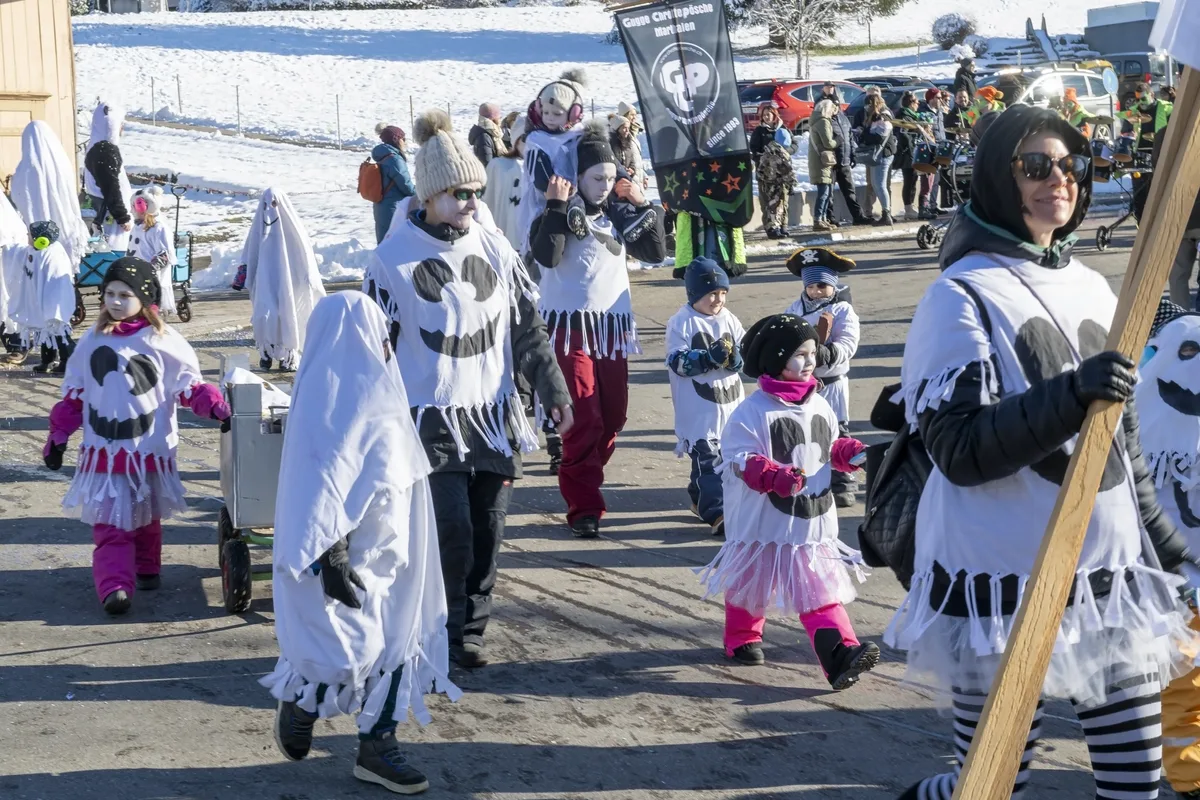 Die grosse Gruppe «Happy Gspänstli» durfte den zweiten Platz bei der Maskenprämierung abholen. Eine Gruppe spaziert bei schönstem Wetter an der Fassnacht.